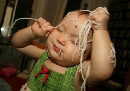 Funny kid enjoying spaghetti